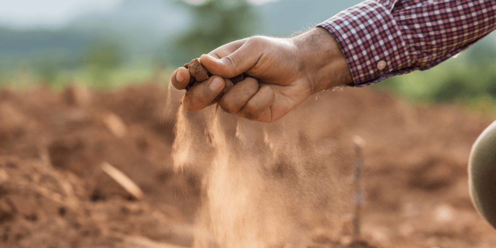mao de produtor rural pegando solo seco mostrando periodo de estiagem